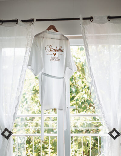Brautmorgen-Moment mit personalisiertem Bademantel am Fenster – Hochzeitsfotografie Lahr mit Persönlichkeit.