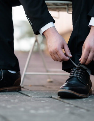 Bräutigam beim Schnüren seiner Schuhe – ruhiger Vorbereitungs-Moment mit Stil. Hochzeitsfotografie Lahr mit Persönlichkeit.