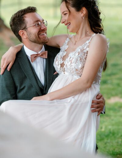Bräutigam hält seine Braut im Arm, beide lachen verliebt – emotionale Hochzeitsfotografie Lahr mit Persönlichkeit.