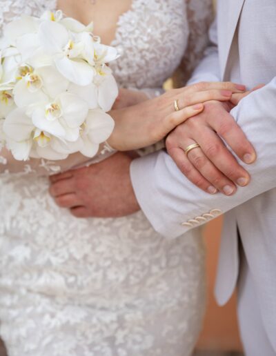 Detailaufnahme der Hände mit Eheringen und weißem Brautstrauß – Helene Karsten Hochzeitsfotografie verewigt die kleinen großen Momente.