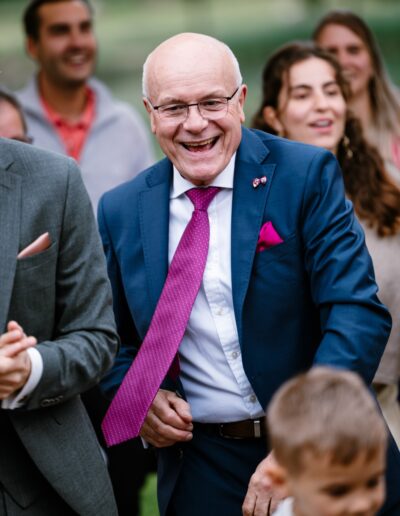 Ein fröhlicher Hochzeitsgast lacht aus vollem Herzen – ein Moment echter Lebensfreude, wie ihn die Hochzeitsfotografie lebendig macht.