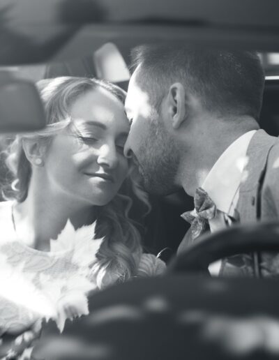 Eine zarte Spiegelung im Auto zeigt das Brautpaar beim Hochzeitsshooting – ein fast-küssender Moment voller Intimität, Licht und Schatten, eingefangen von einer Hochzeitsfotografin mit Gespür für Details.