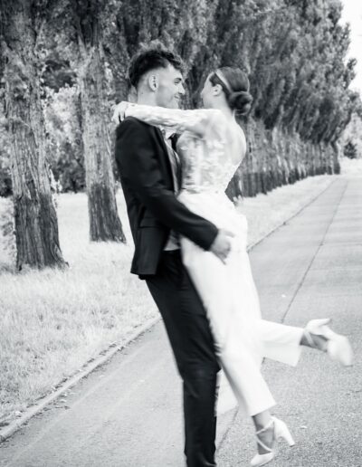Schwarzweißaufnahme eines Brautpaars in Bewegung – sie tanzen fast durch den Moment. Hochzeitsfotografie Lahr mit Persönlichkeit.