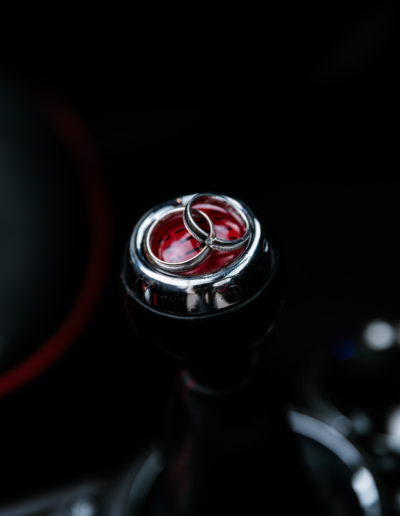 Ringe im Auto auf der Gangschaltung, Detailaufnahme der Ringe auf rotem Hintergrund