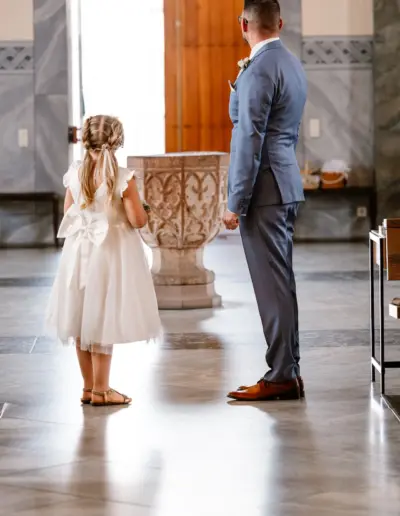 Bräutigam und Tochter stehen in der Kirche und schauen beide zur Tür erwartungsvoll. warten auf die Ankunft der Braut.