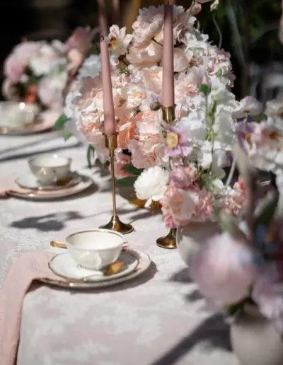 Ein kleiner Ausschnitt von einem dekoriertem Tisch mit Kaffeegedeck. Drapiert mit ganz vielen hellen Blumen